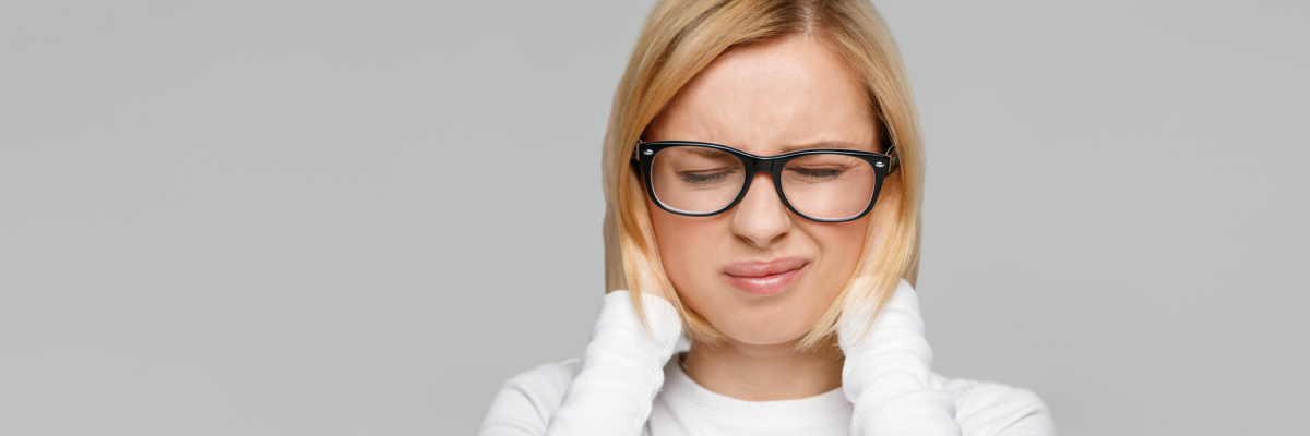 A woman lifting up her glasses and blinking